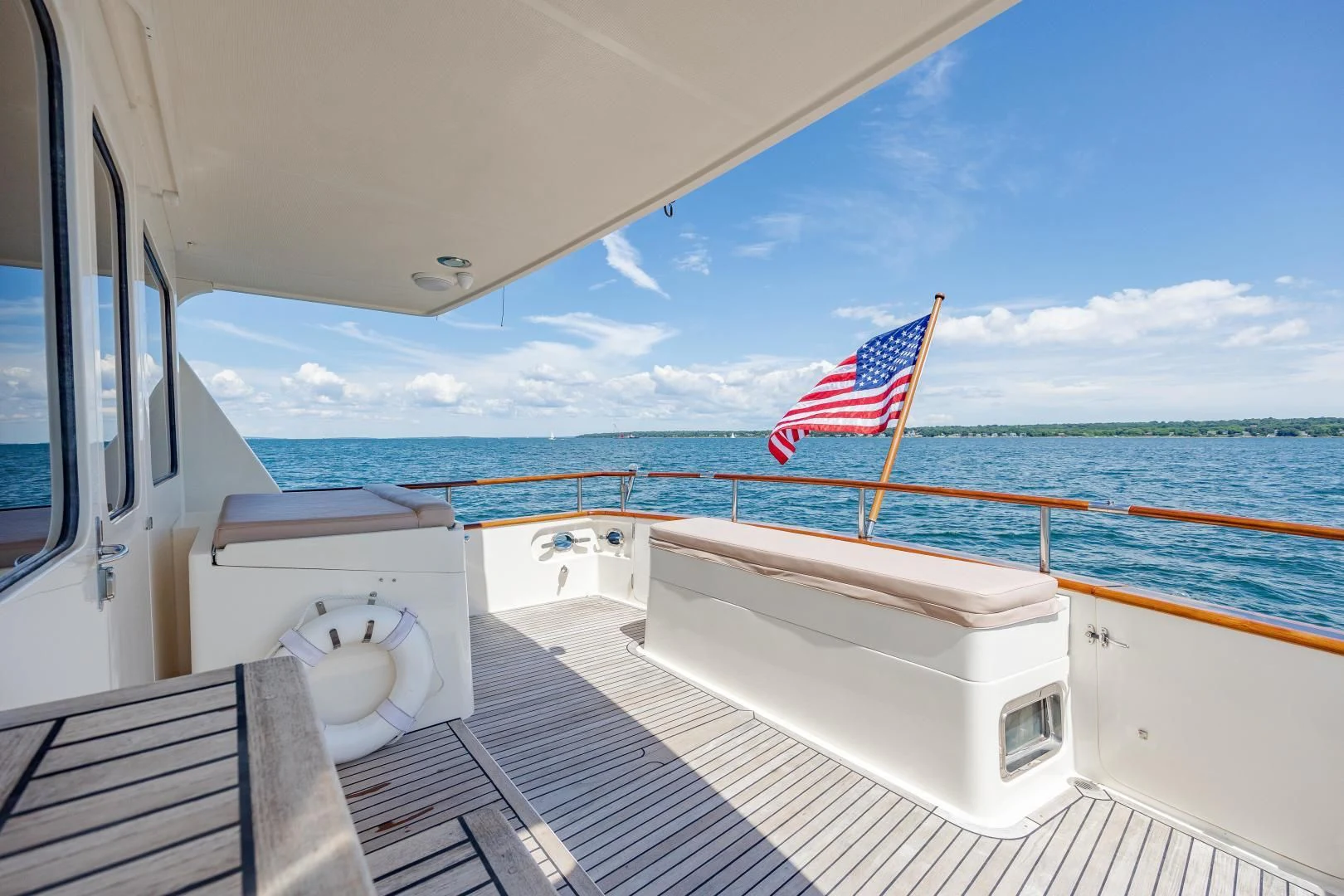 a boat with a flag on the deck aboard DISCONNECTED Yacht for Sale