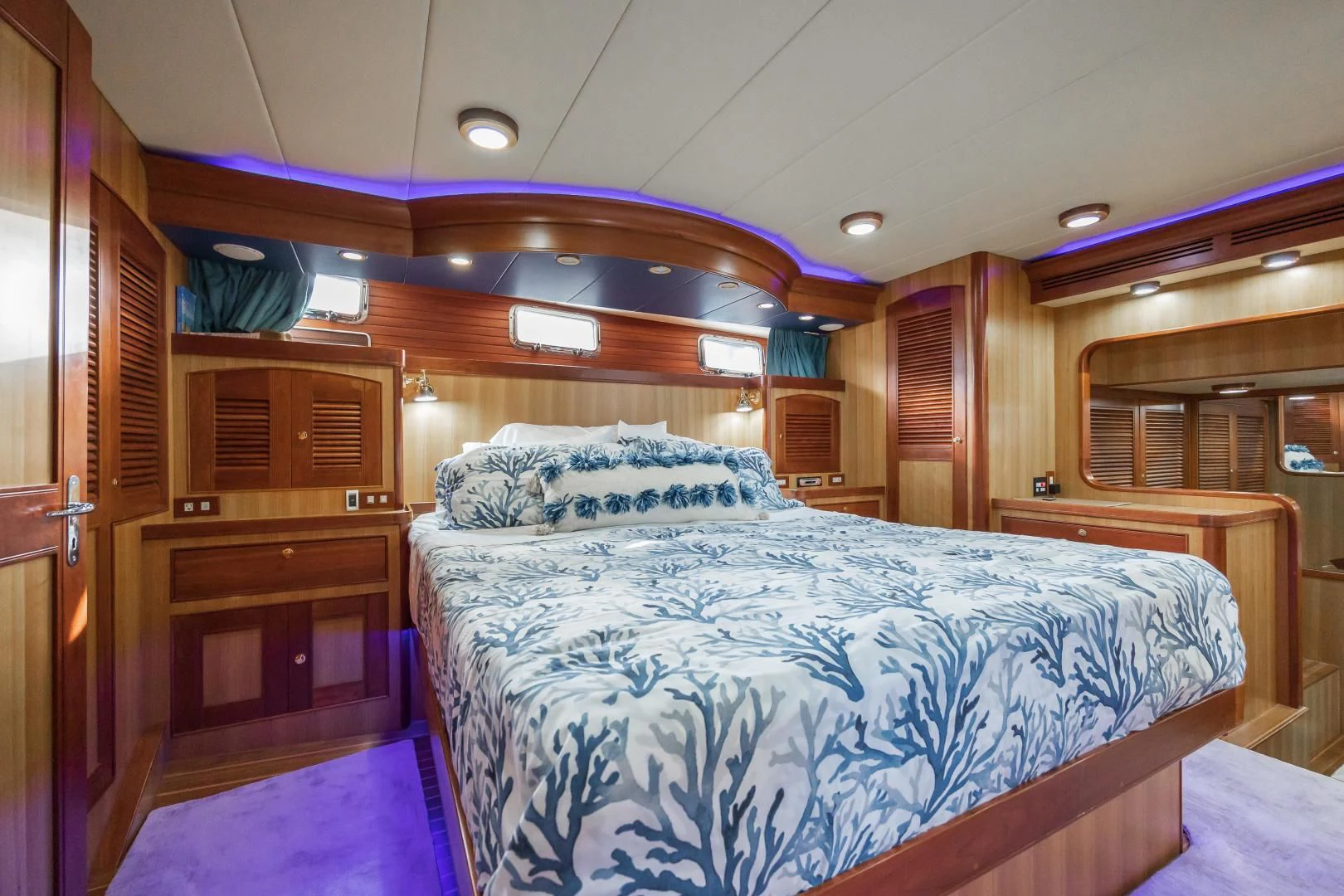 a bedroom with a bed and a wood door aboard DISCONNECTED Yacht for Sale