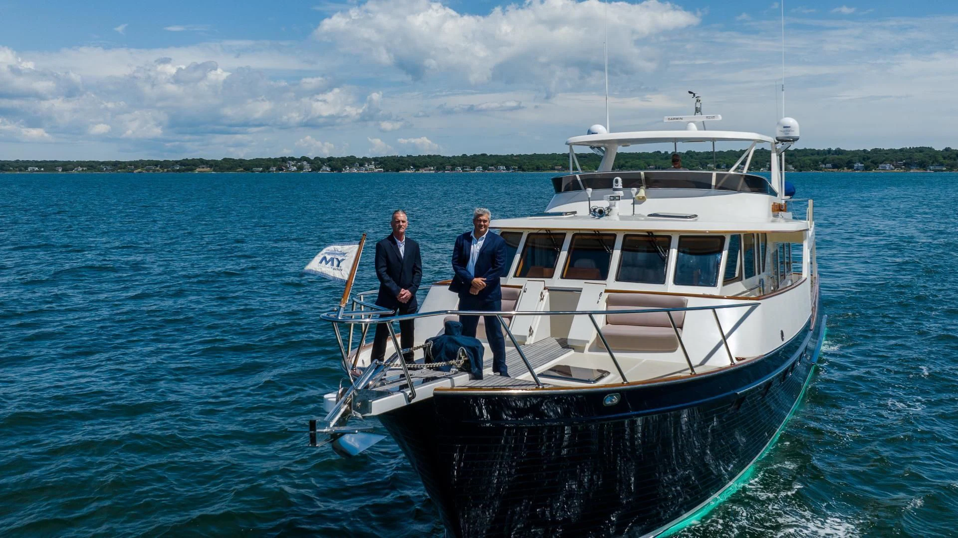 a couple of men standing on a boat in the water aboard DISCONNECTED Yacht for Sale