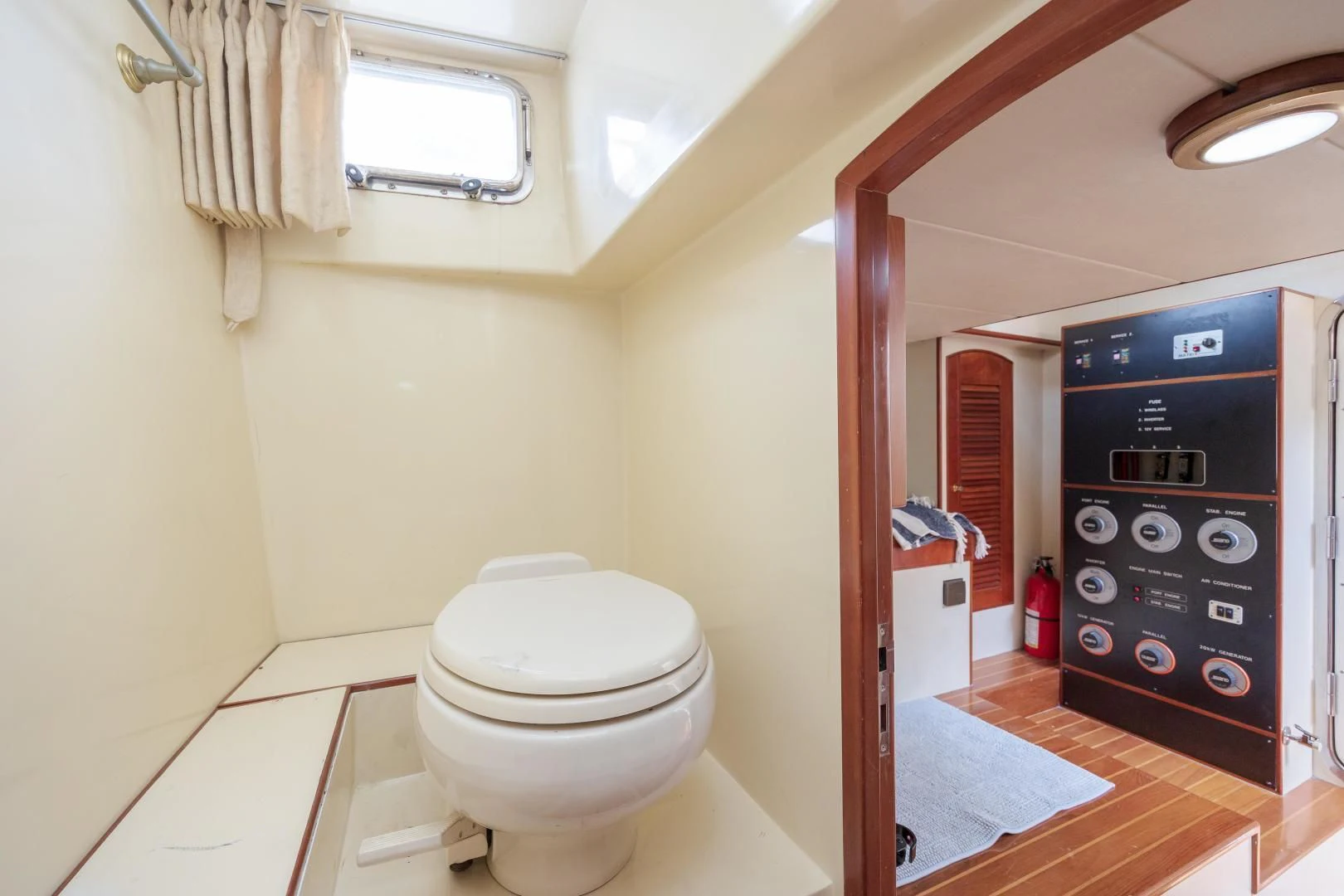 a bathroom with a toilet and a washing machine aboard DISCONNECTED Yacht for Sale