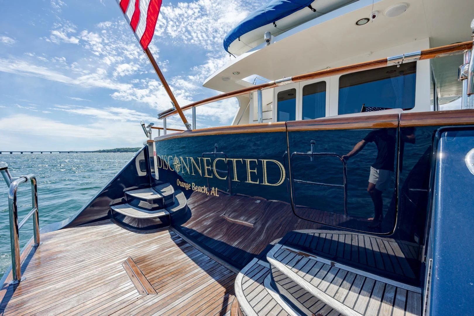 a person on a boat holding a flag aboard DISCONNECTED Yacht for Sale