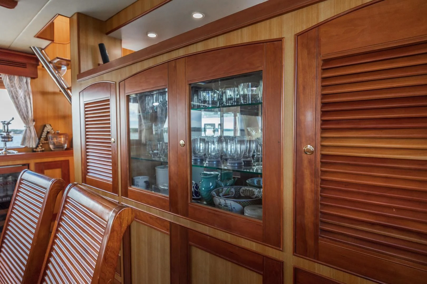 a wooden cabinet with glass doors aboard DISCONNECTED Yacht for Sale