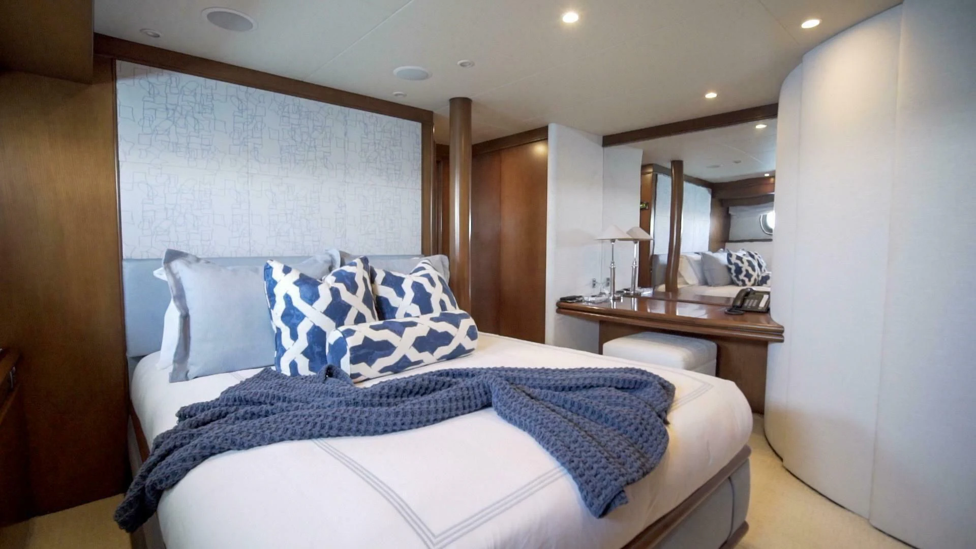 a bed with blue and white sheets aboard AT LAST Yacht for Charter