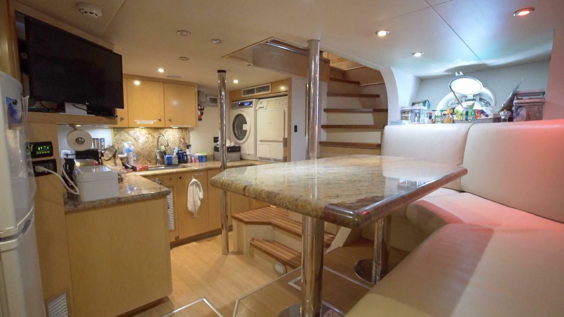 a kitchen with a table and a couch aboard AT LAST Yacht for Charter