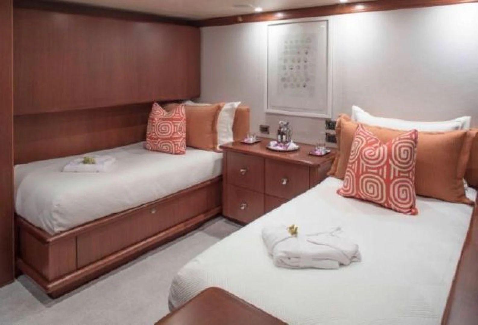 a room with a bed and a dresser aboard AT LAST Yacht for Charter