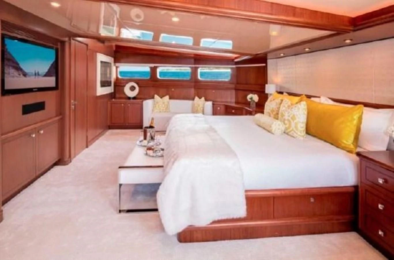 a room with a bed and a television aboard AT LAST Yacht for Charter