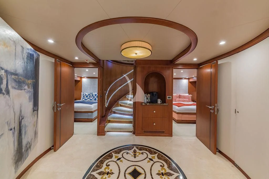 a large room with a staircase and a rug aboard AT LAST Yacht for Charter