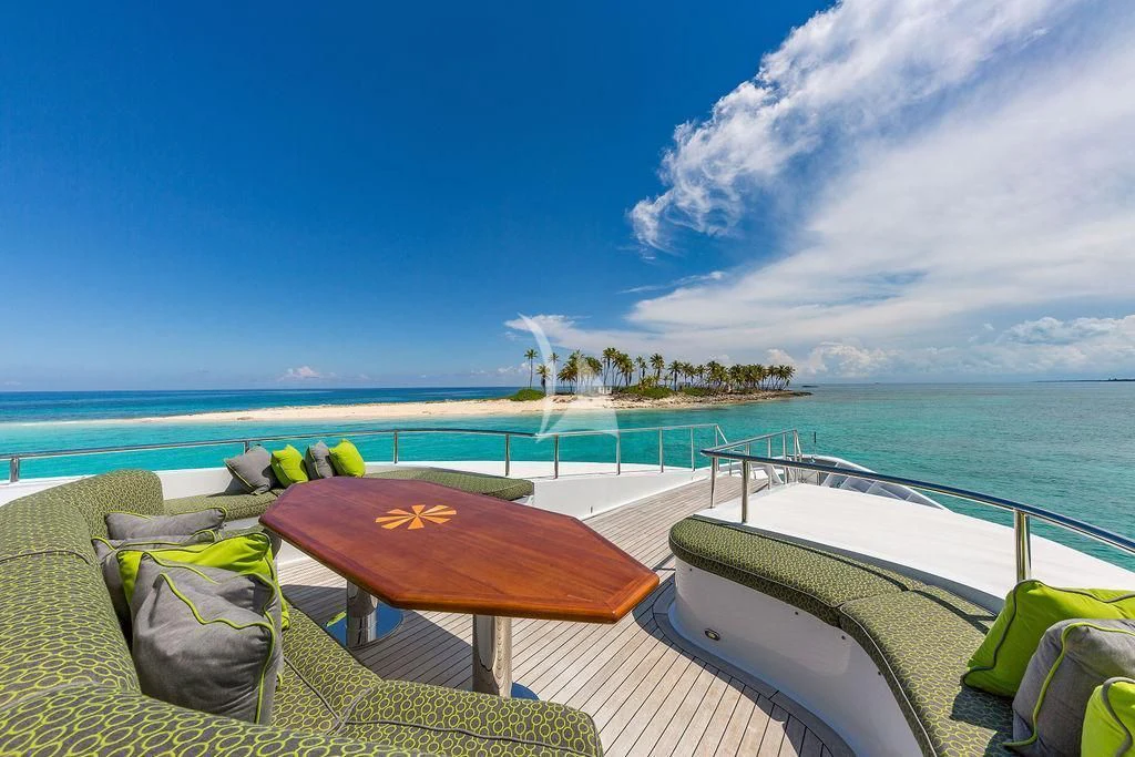 a deck with a pool and a beach in the background aboard AT LAST Yacht for Charter