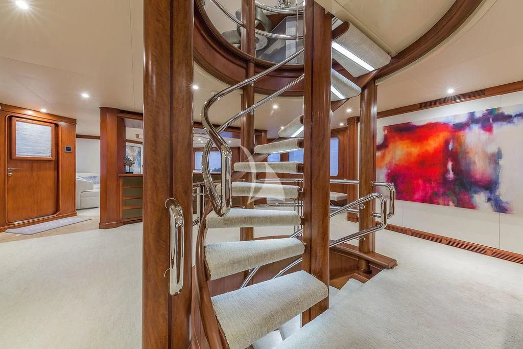 a room with a staircase and paintings aboard AT LAST Yacht for Charter
