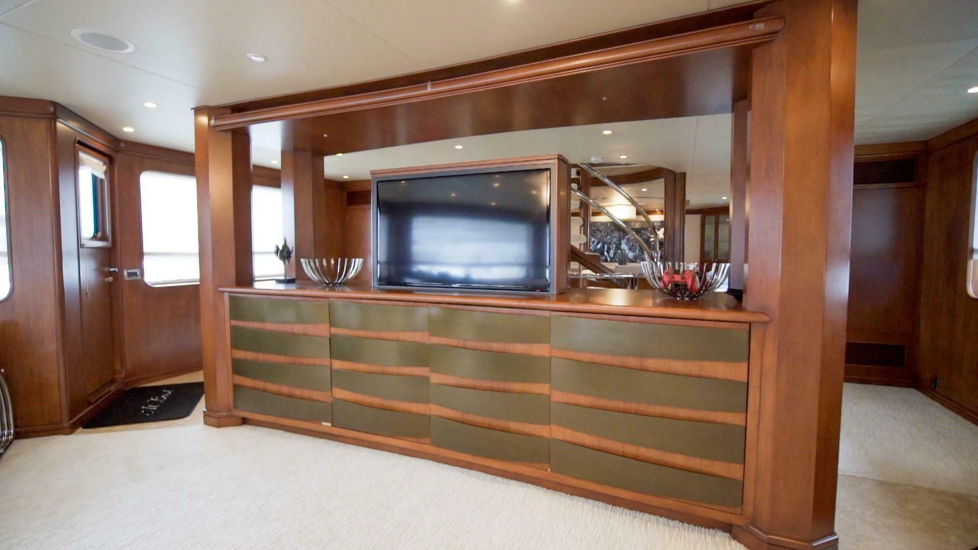 a room with a tv and wood cabinets aboard AT LAST Yacht for Charter