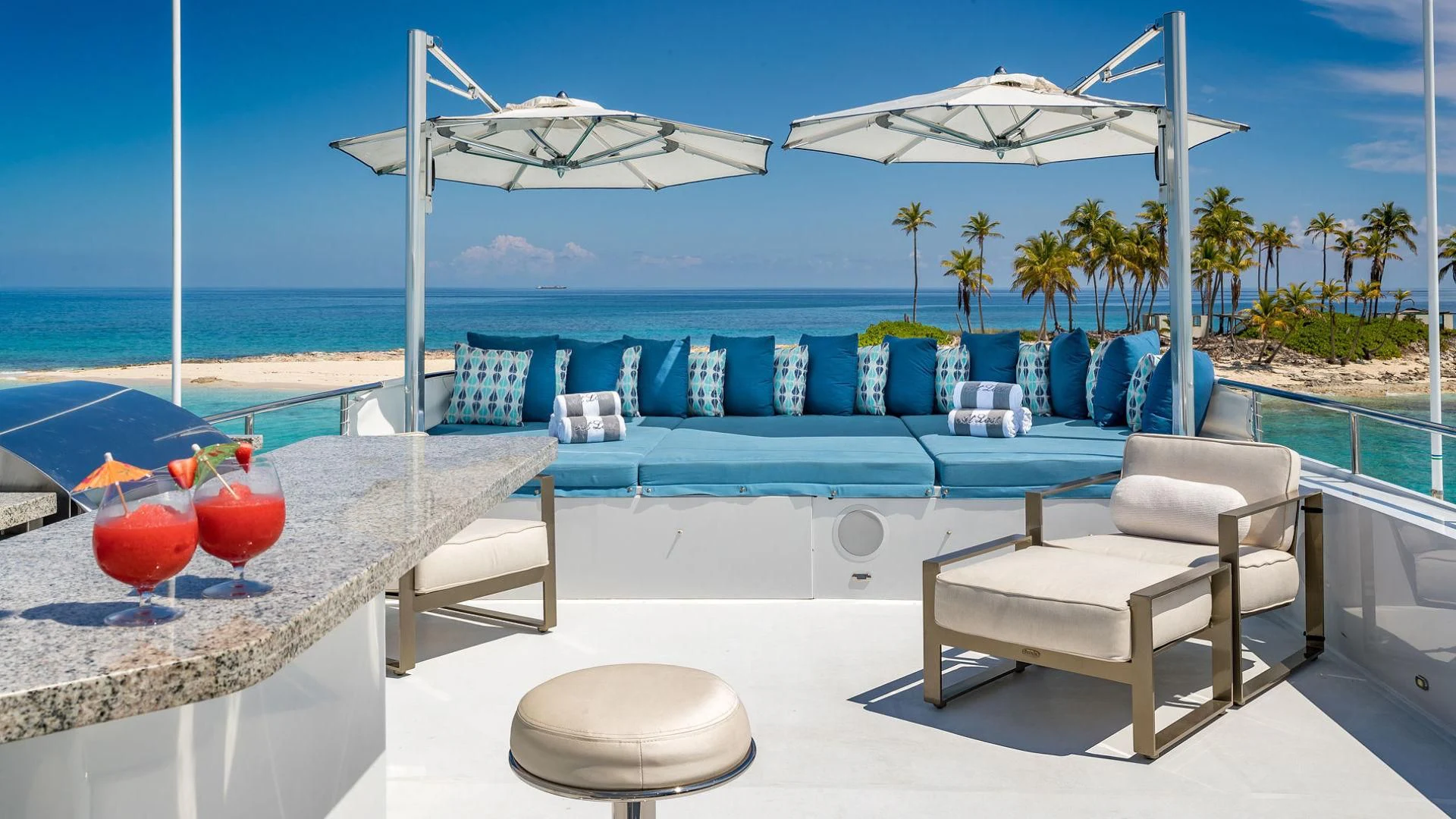 a pool with lounge chairs and umbrellas on a beach aboard AT LAST Yacht for Charter