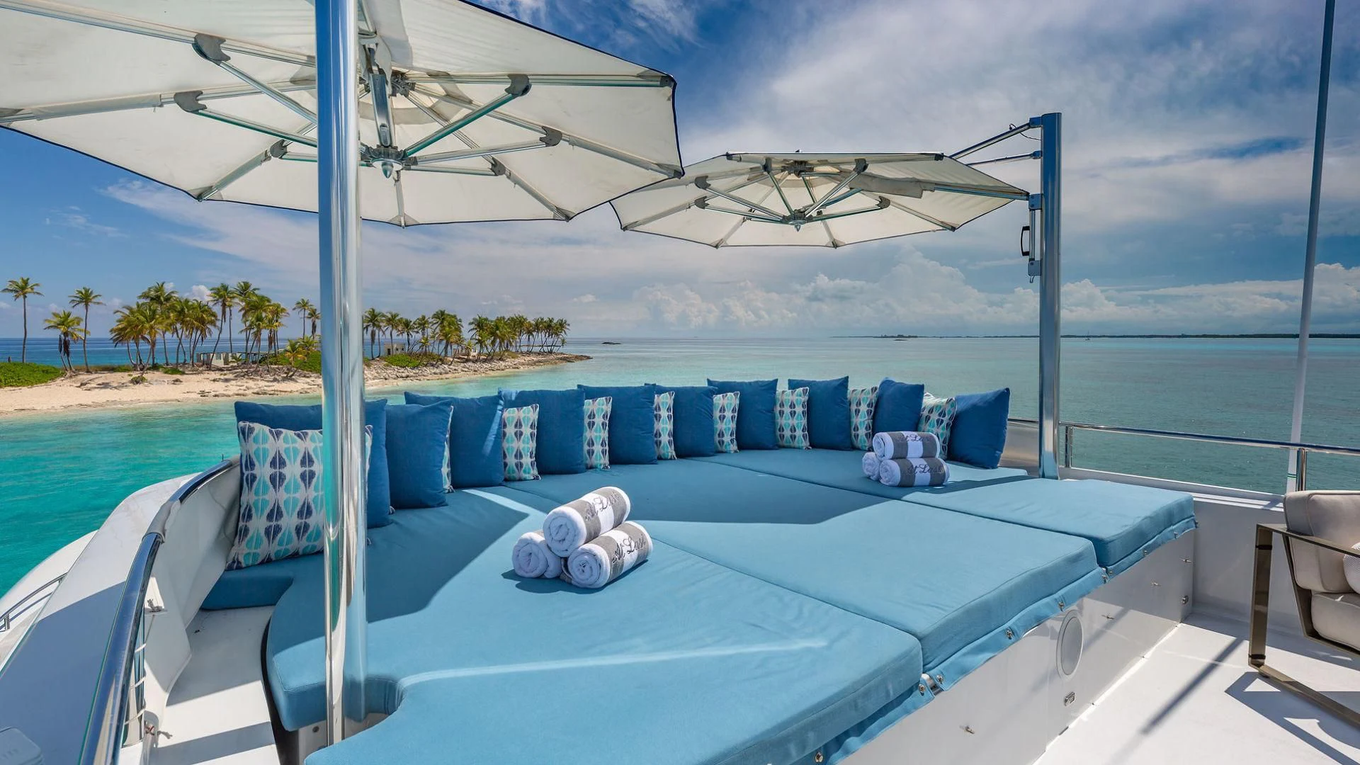 a large blue lounge chair on a deck overlooking a body of water aboard AT LAST Yacht for Charter