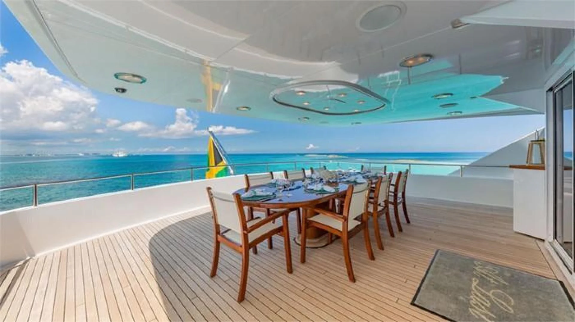 a table and chairs on a deck overlooking a large pool aboard AT LAST Yacht for Charter