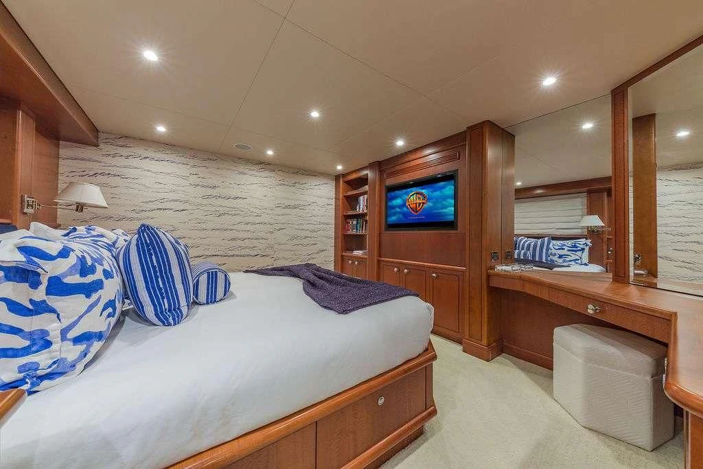 a bedroom with a bed and a tv on the wall aboard AT LAST Yacht for Charter