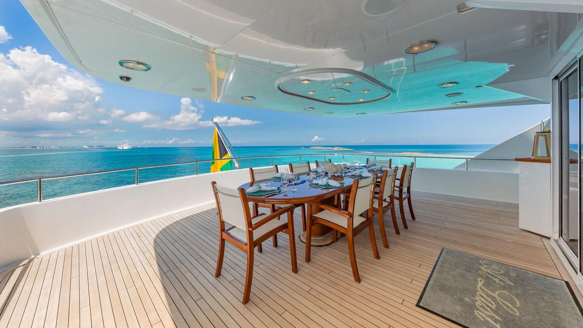 a table and chairs on a deck overlooking a pool aboard AT LAST Yacht for Charter