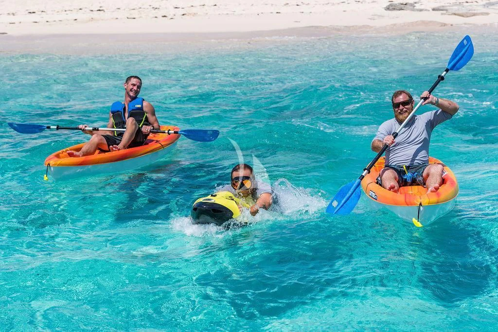 a group of people in kayaks aboard AT LAST Yacht for Charter