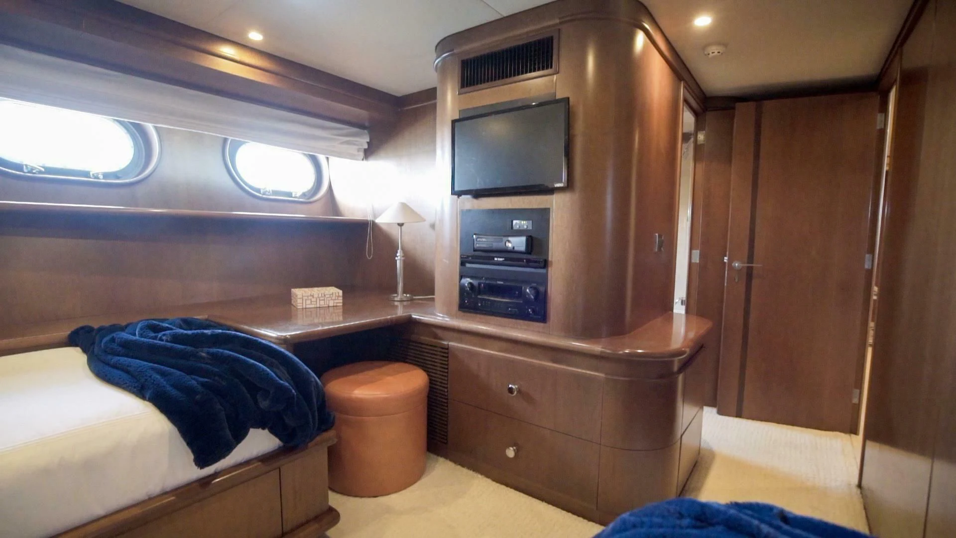 a room with a bed and a television aboard AT LAST Yacht for Charter
