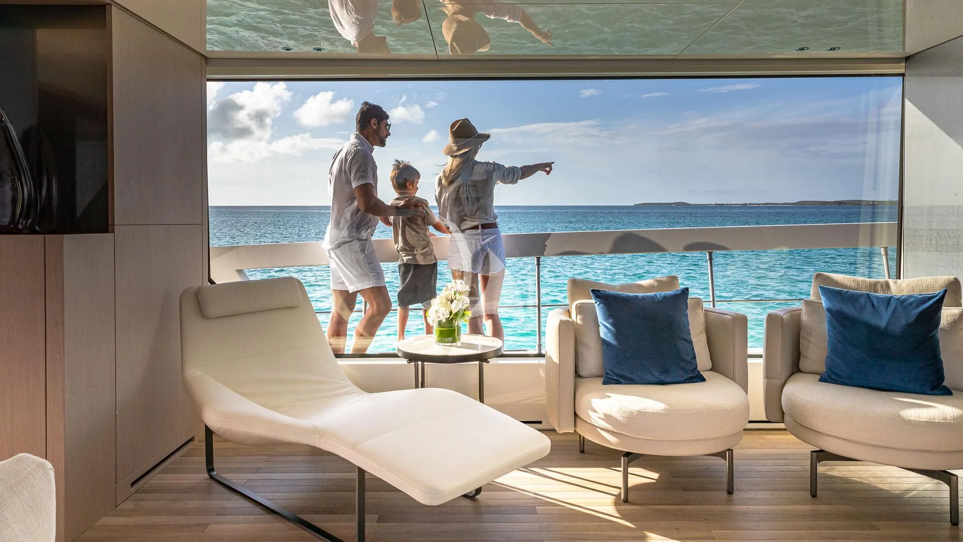 a group of people standing on a balcony overlooking a body of water aboard NO MATTER WHAT Yacht for Charter