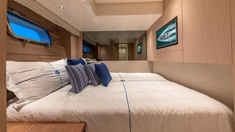 a bed with a white sheet and blue pillows aboard NO MATTER WHAT Yacht for Charter
