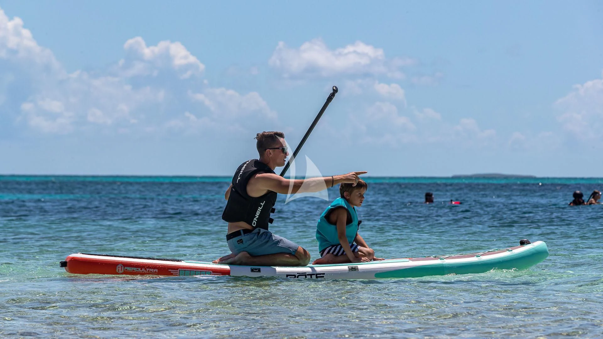 a man and a boy on a surfboard in the ocean aboard NO MATTER WHAT Yacht for Charter