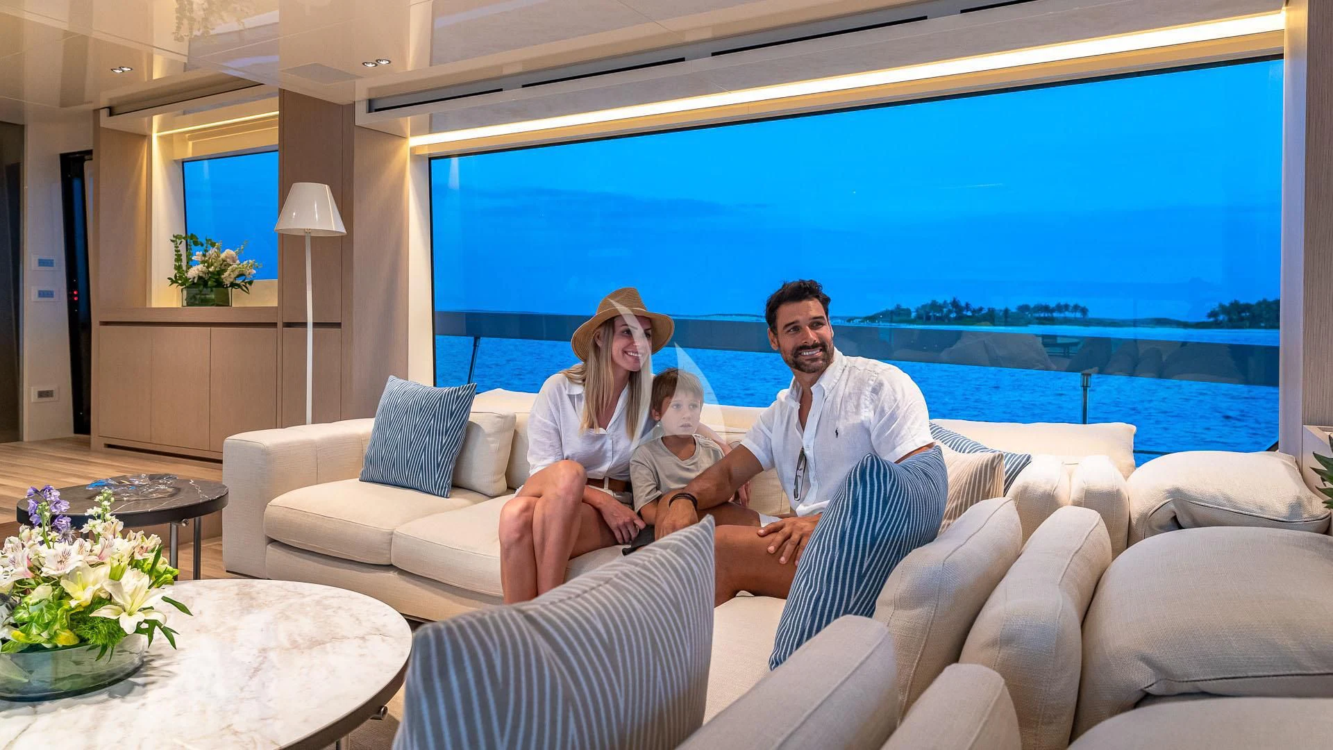 a man and woman sitting on a couch with a large blue ocean behind them aboard NO MATTER WHAT Yacht for Charter