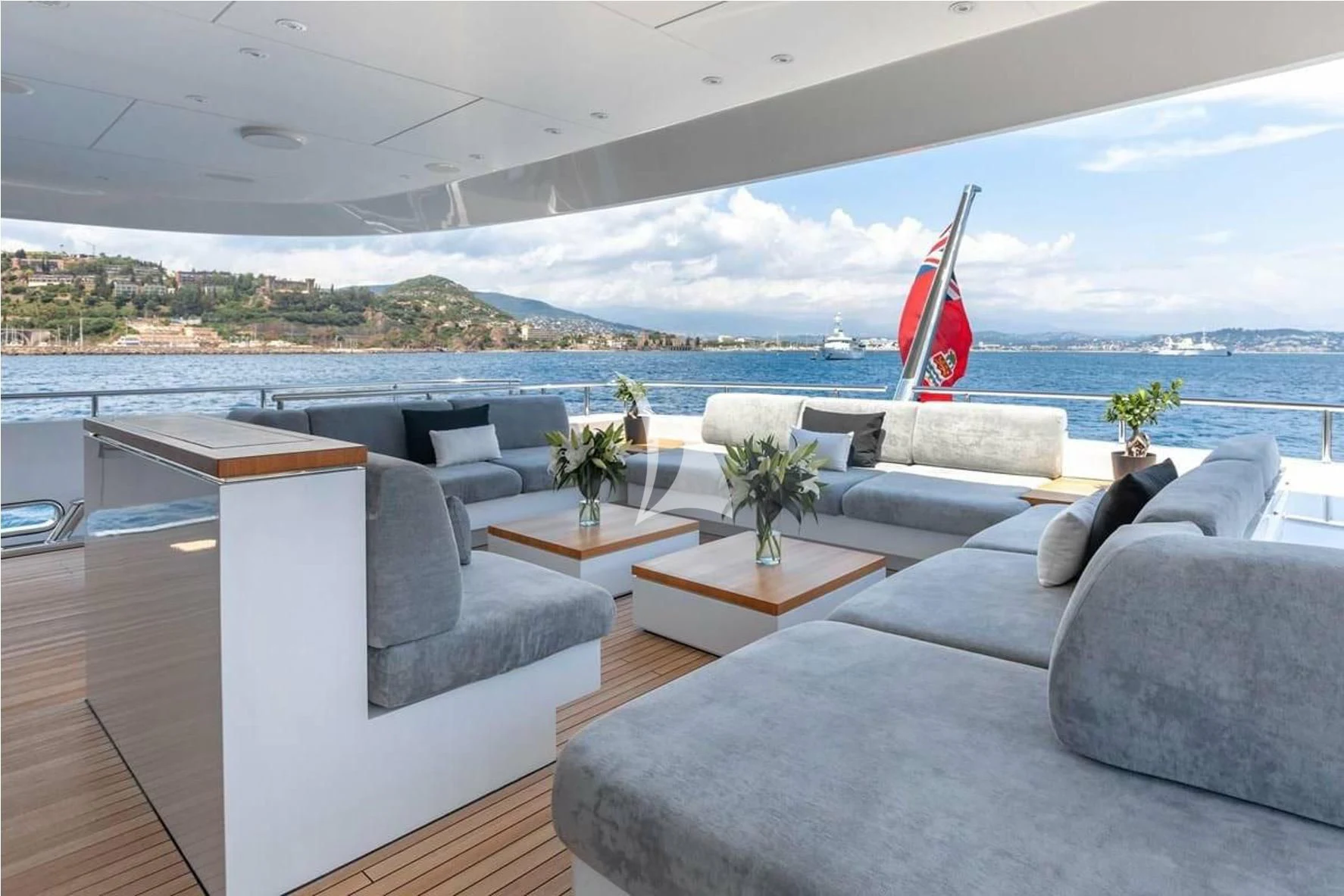 a living room with a large body of water and a large red and white flag aboard PEARL Yacht for Sale