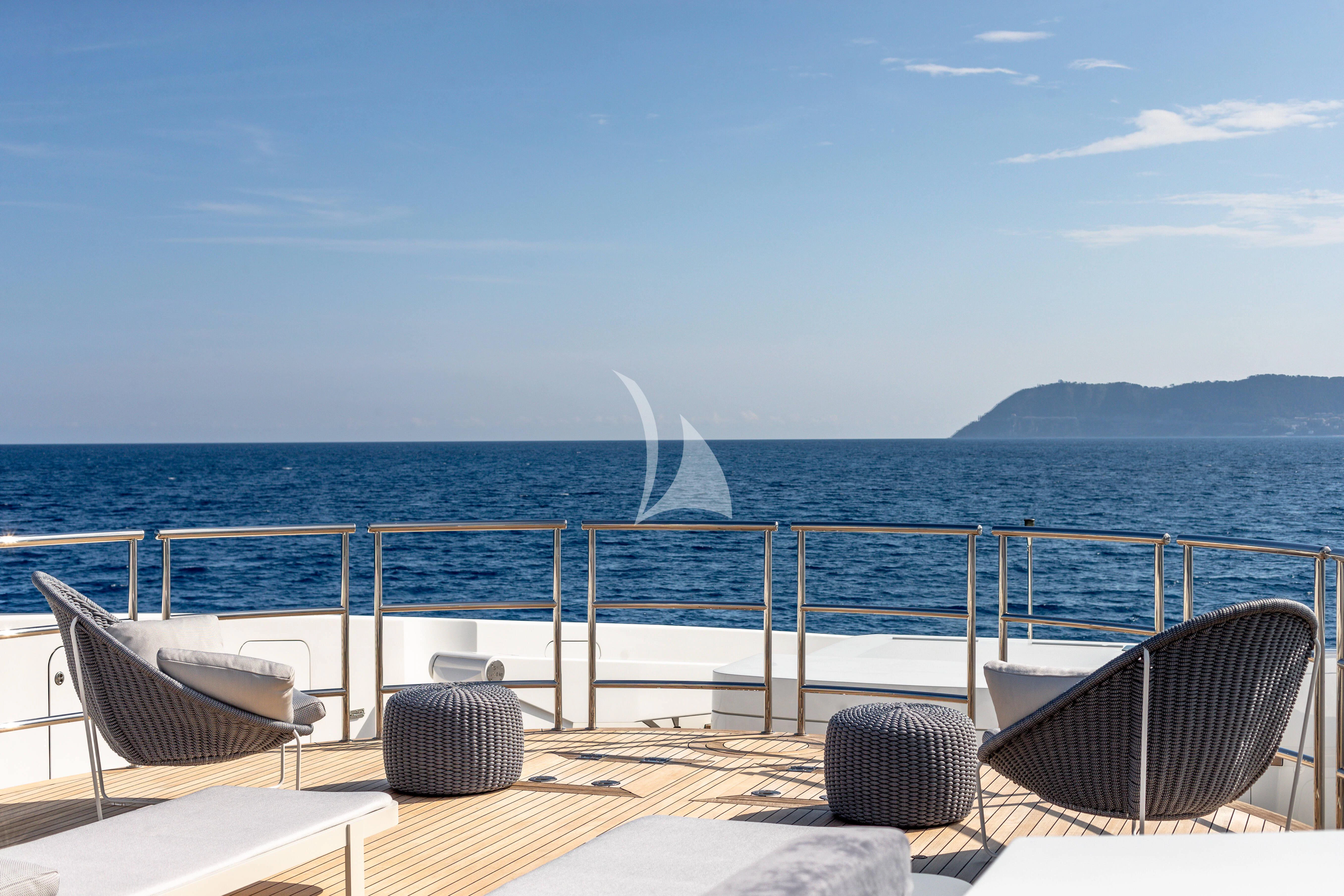 a deck with chairs and a body of water in the background aboard PEARL Yacht for Sale