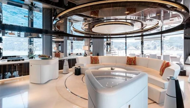 a large room with a large white couch and a large round table aboard PEARL Yacht for Sale