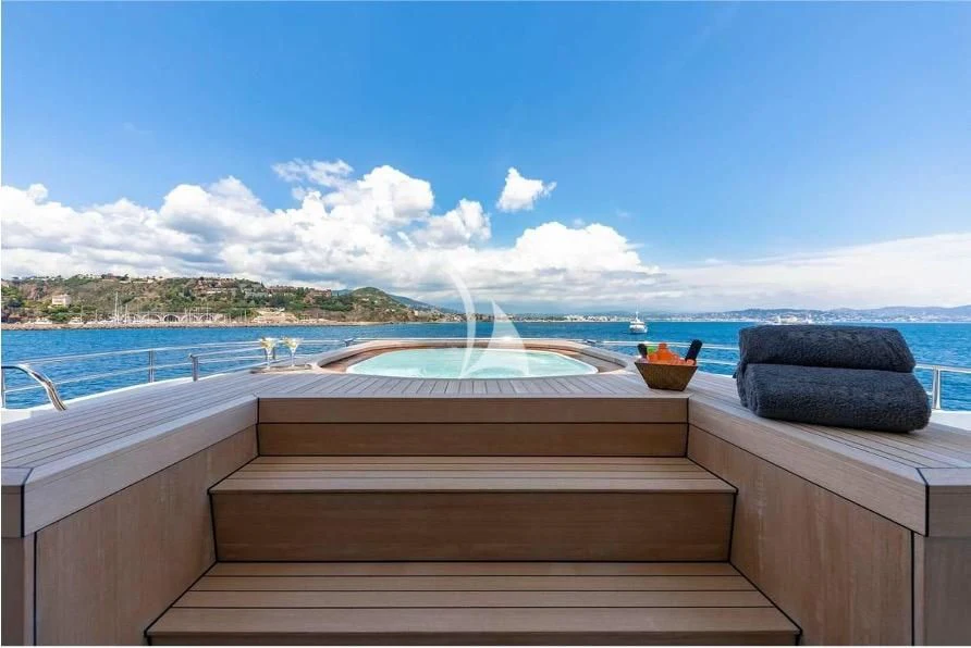 a deck with a view of the ocean and the beach aboard PEARL Yacht for Sale