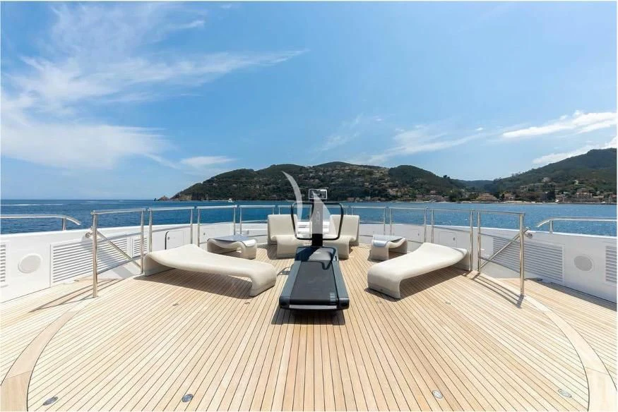 a deck with a large body of water and a large mountain in the background aboard PEARL Yacht for Sale