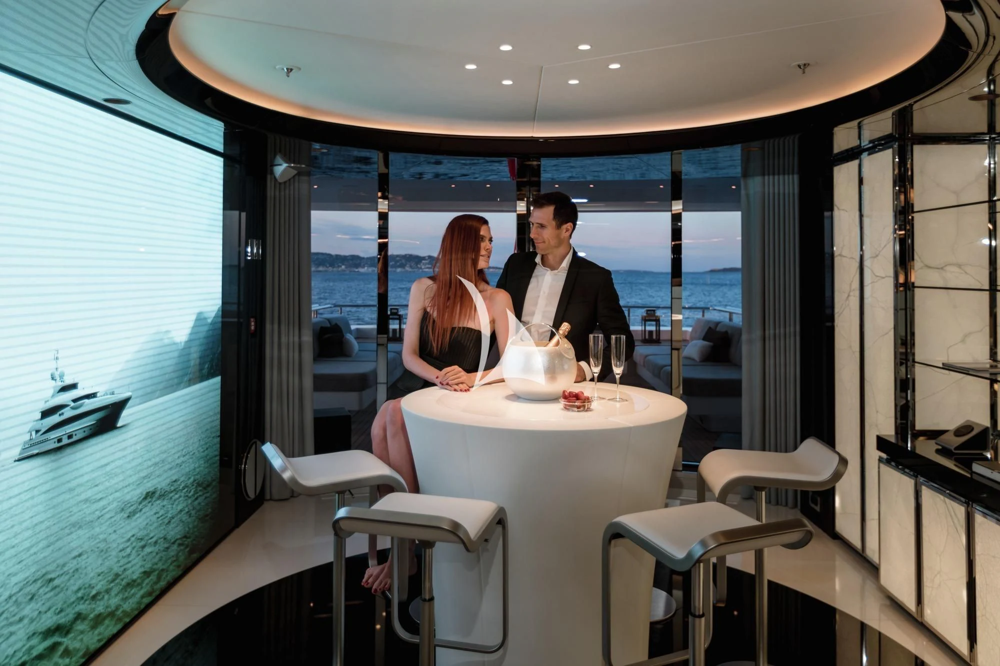 a man and woman sitting at a table in a restaurant aboard PEARL Yacht for Sale