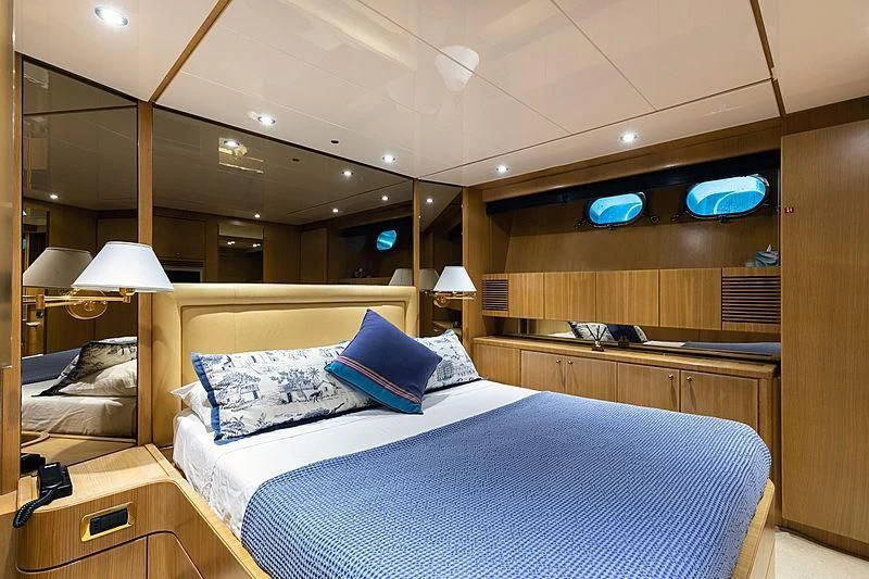 a bed with blue pillows aboard GAVEAU Yacht for Sale
