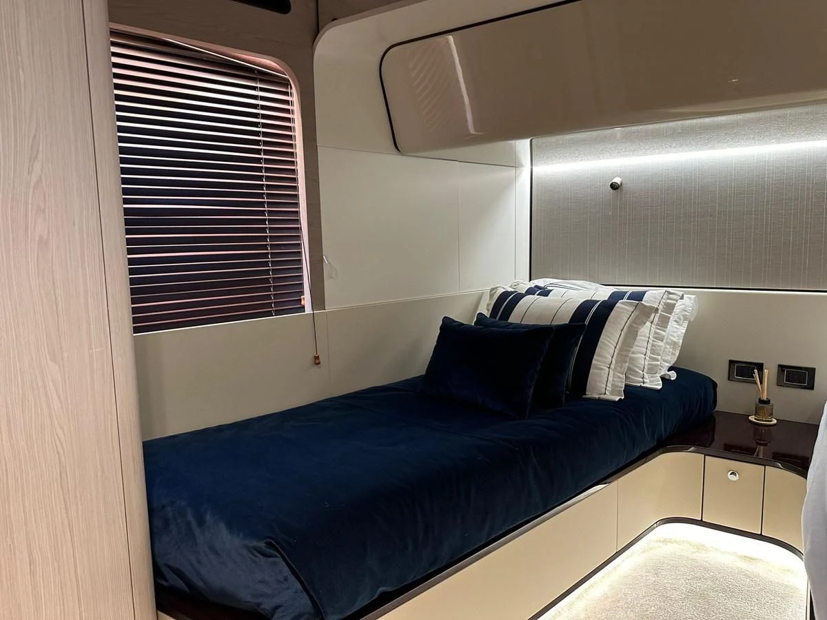 a bed with blue sheets aboard BETTY Yacht for Sale