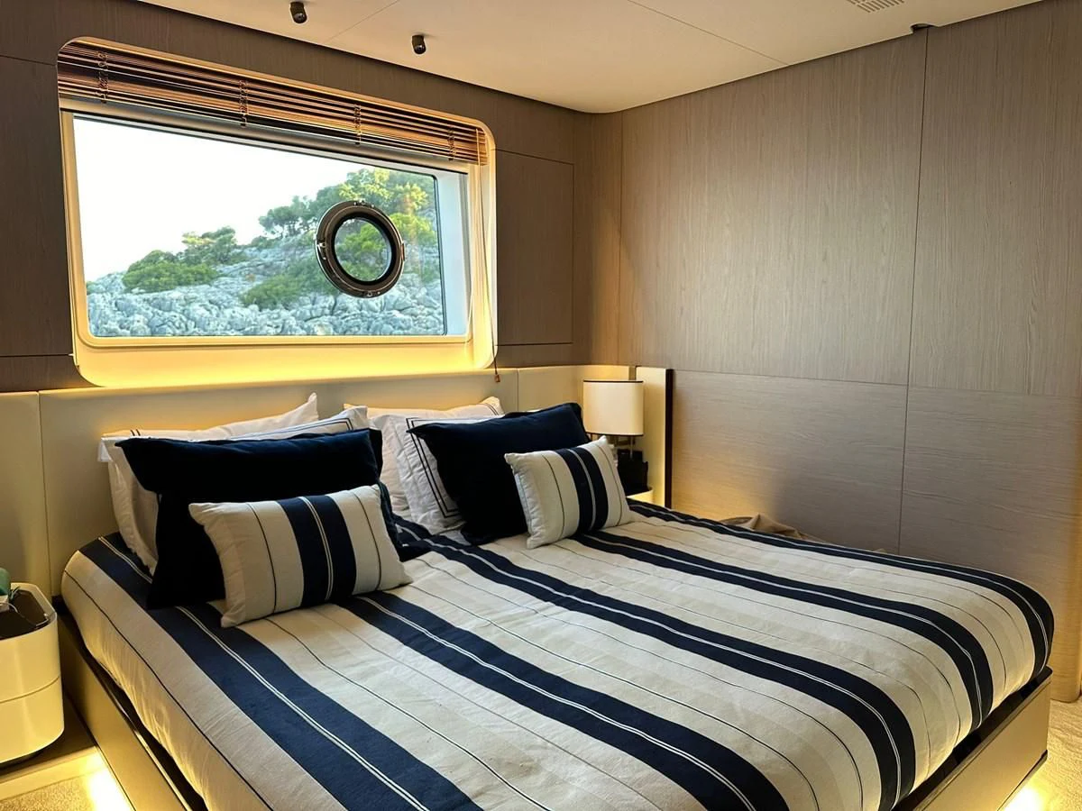 a bed with blue and white sheets aboard BETTY Yacht for Sale