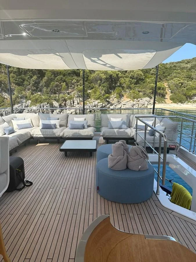 a deck with a view of a lake and a large white tent aboard BETTY Yacht for Sale