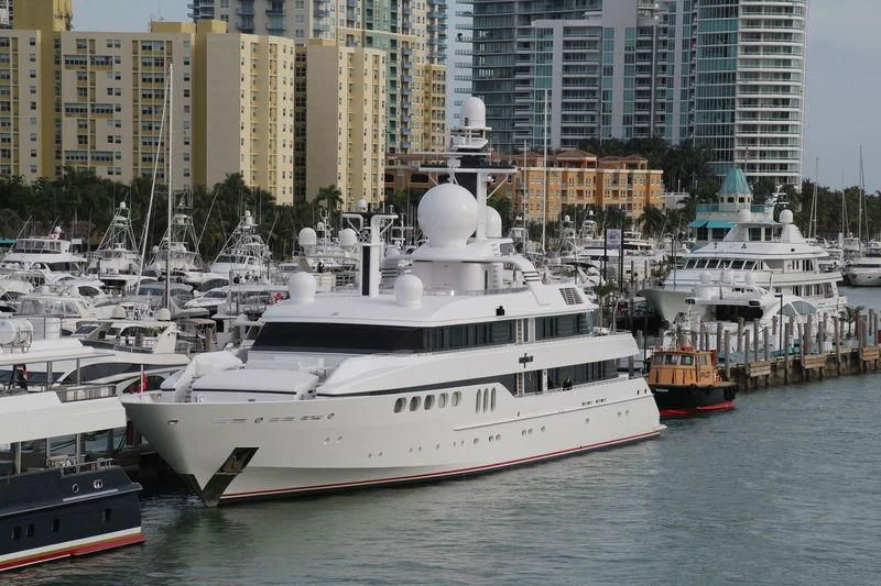 a large white boat in a harbor aboard MYLIN IV Yacht for Sale