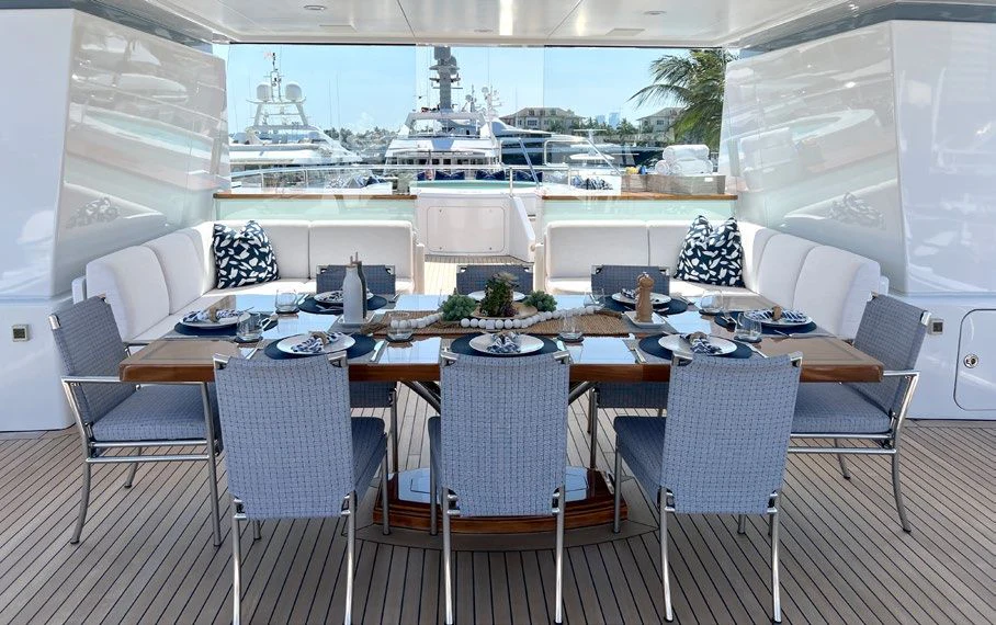 a table with chairs and a large window with a view of the water aboard SPORT Yacht for Sale
