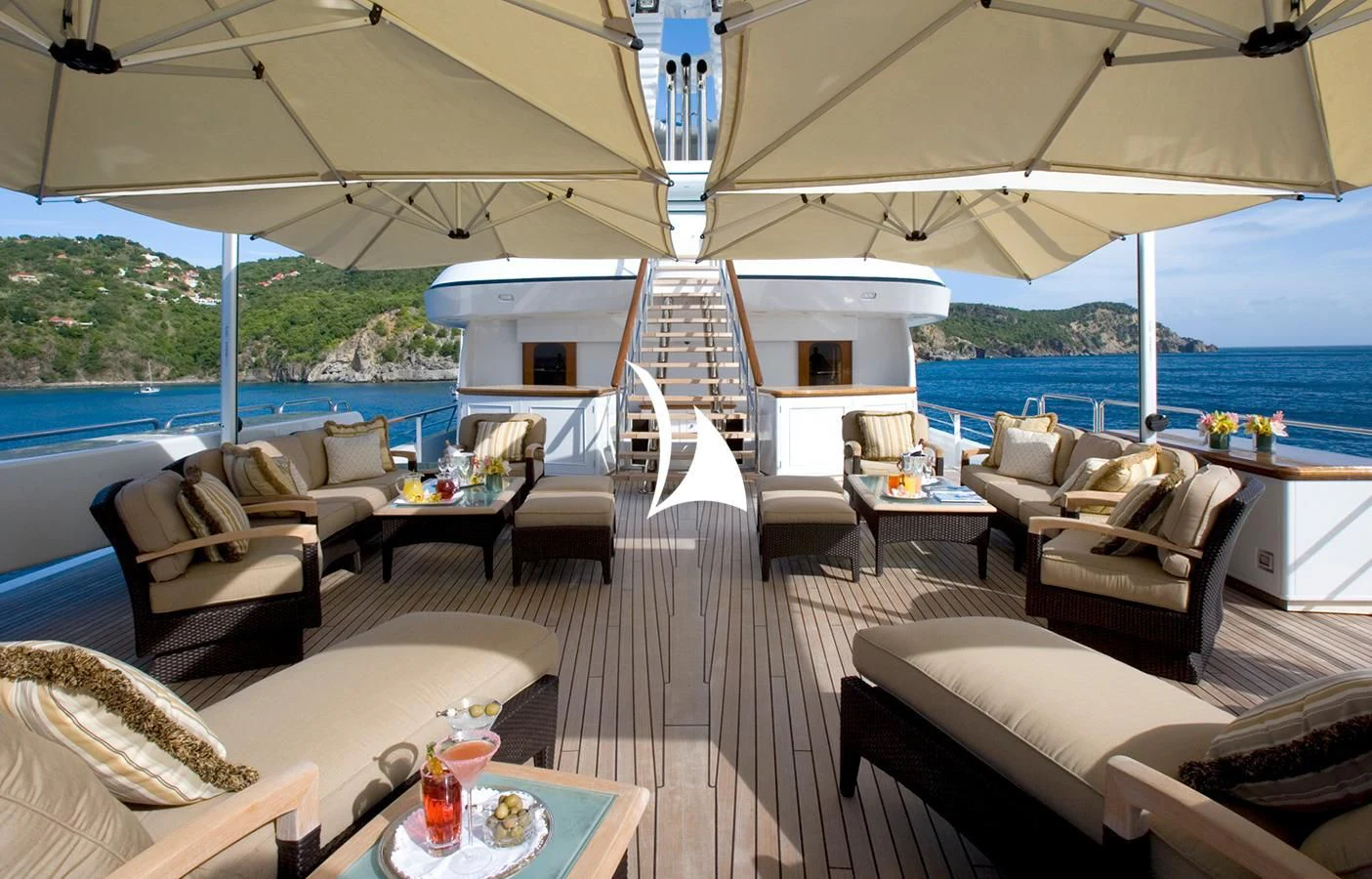a room with a large white tent and a table with chairs and a view of the water and aboard UTOPIA Yacht for Sale