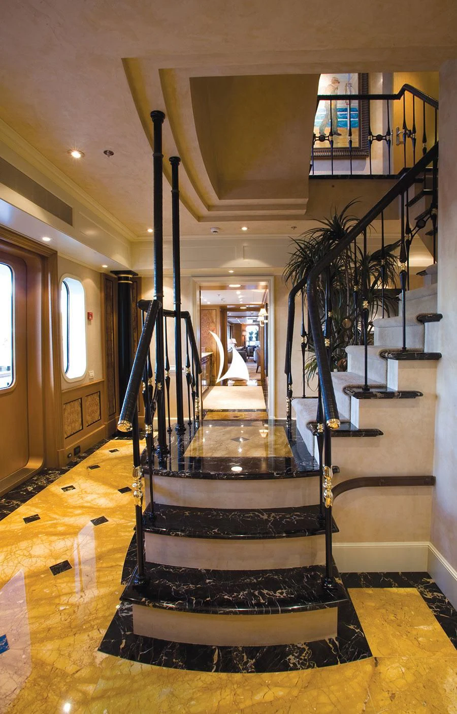 a black and white staircase in a house with a chandelier aboard UTOPIA Yacht for Sale