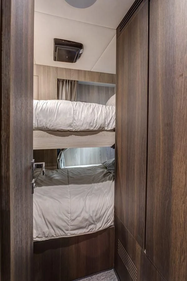 a room with a bed and a wood door aboard CAPTAIN MORGAN II Yacht for Sale