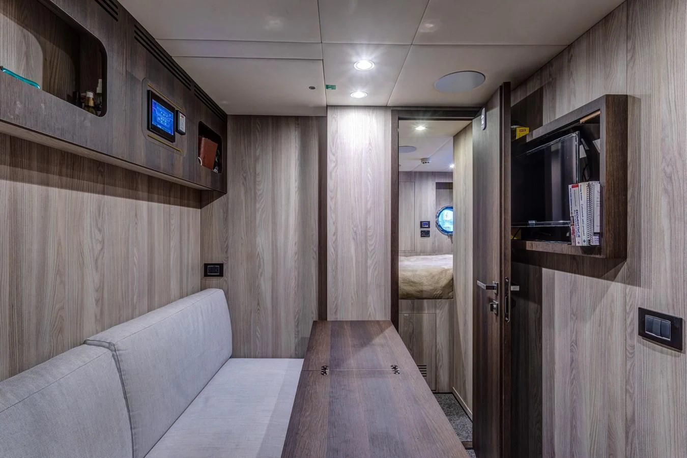 a room with a couch and a television on the wall aboard CAPTAIN MORGAN II Yacht for Sale