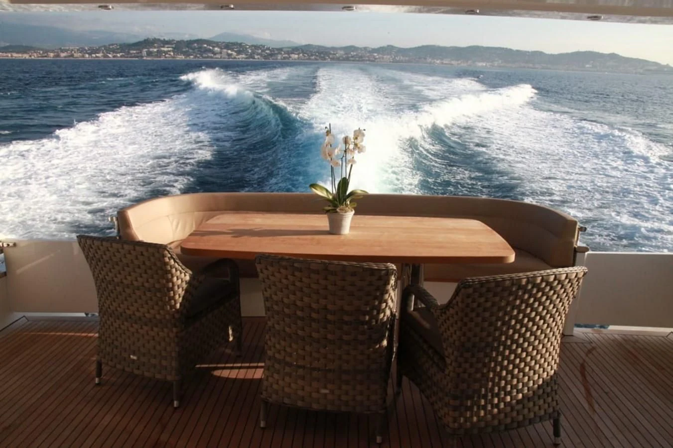 a table and chairs on a deck overlooking a large body of water aboard ORION Yacht for Sale
