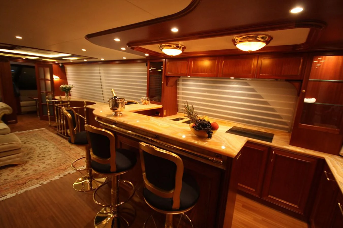 a large kitchen with a bar and chairs aboard ORION Yacht for Sale