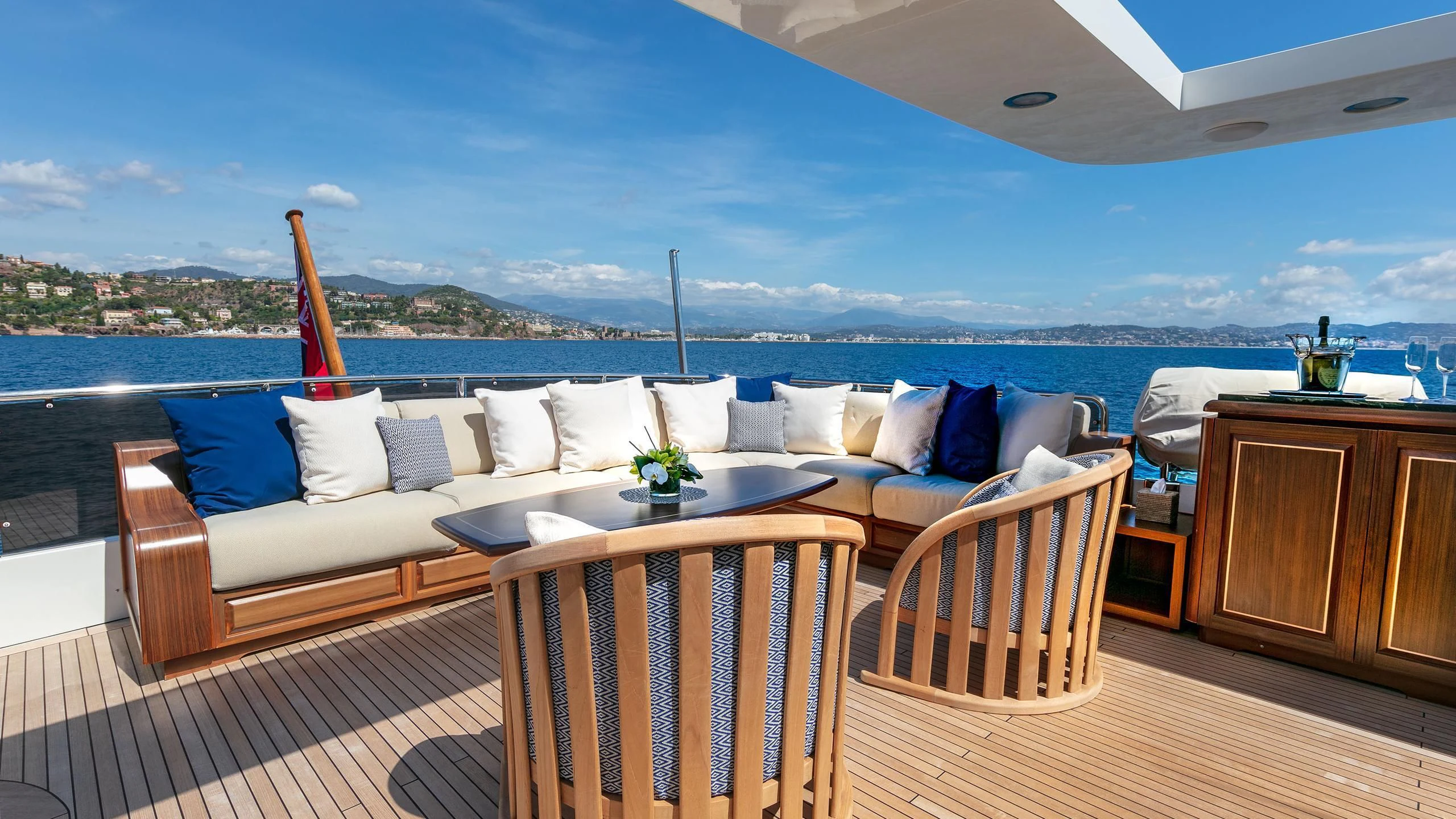 a large white sofa with blue pillows and a view of the city aboard FARFALLINA Yacht for Sale