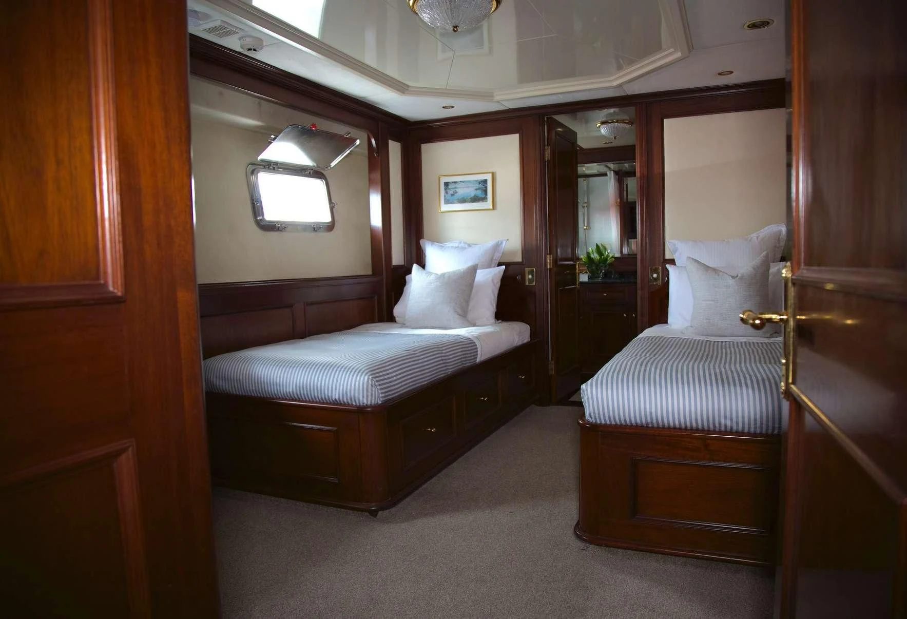 a room with a bed and a mirror aboard PACIFIC MERMAID Yacht for Sale