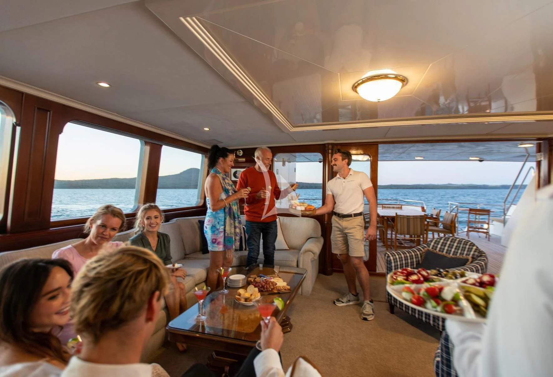 a group of people standing around a table with food on it aboard PACIFIC MERMAID Yacht for Sale
