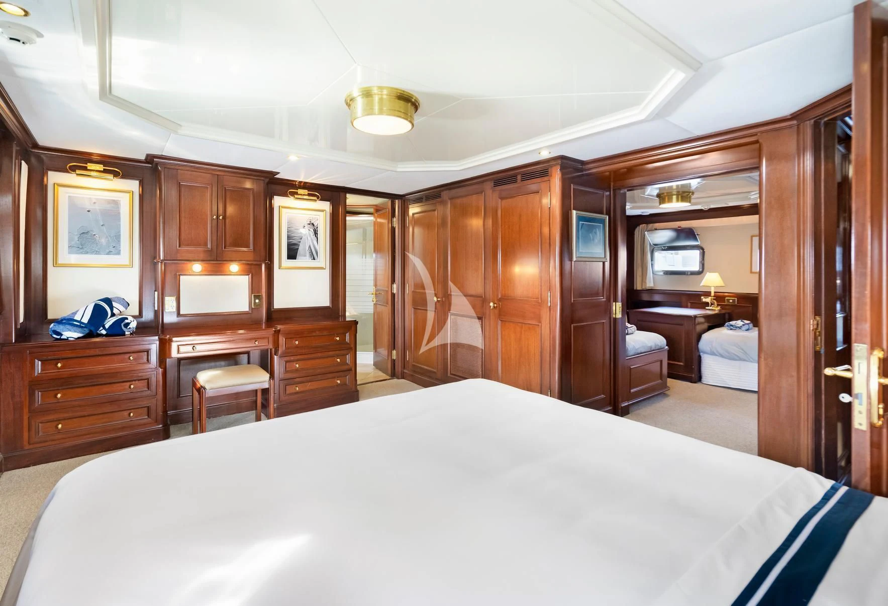 a bedroom with a bed and a desk aboard PACIFIC MERMAID Yacht for Sale