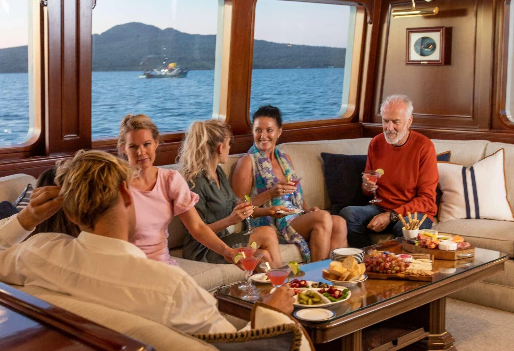a group of people sitting on a couch aboard PACIFIC MERMAID Yacht for Sale