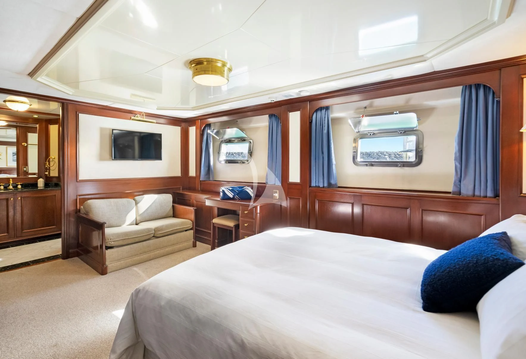 a room with a bed and a couch aboard PACIFIC MERMAID Yacht for Sale