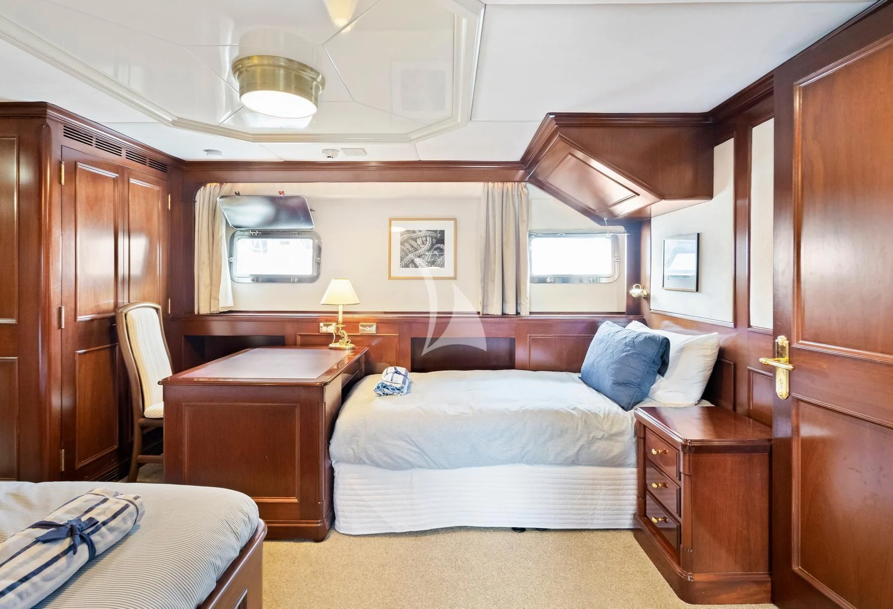 a bedroom with a bed and a desk aboard PACIFIC MERMAID Yacht for Sale